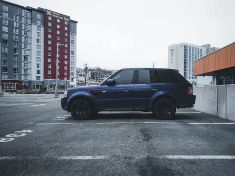 A blue SUV parked in an empty city lot